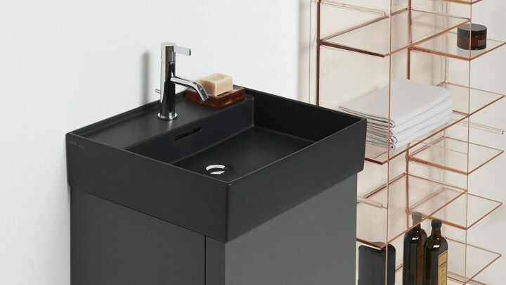 Ein schwarzes Waschbecken über eine schwarz-matten Waschtisch.