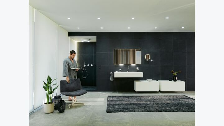 Ein Badezimmer mit dunkler Akzent-Wand und weißen Schränken und Waschbecken.