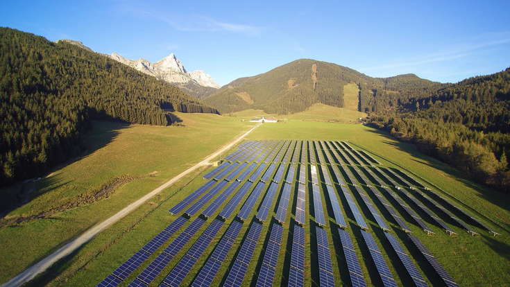 © eco-tec.at Photovoltaics GmbH Eine PV-Freifläche auf einer Wiese in den Bergen.