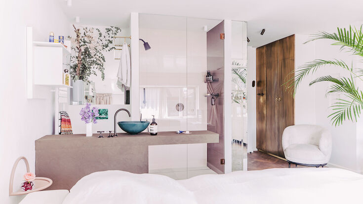 © Dornbracht AG & Co. KG, Iserlohn, Deutschland Das Schlafzimmer mit dem eingebauten Badezimmer. Ein offener Blick führt zu einem blauen Keramikwaschtisch.