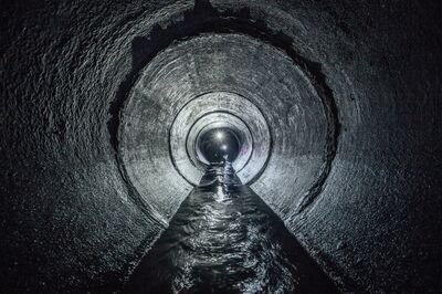 © Mulderphoto - stock.adobe.com Diggers are exploring underground river flowing in round sewer tunnel