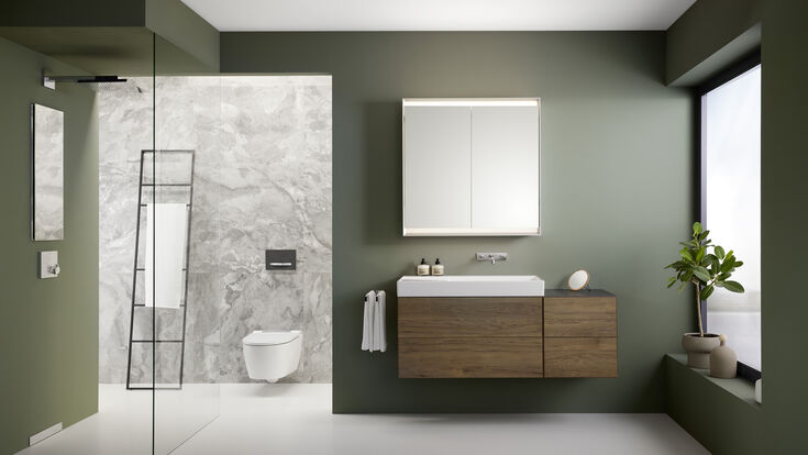 © Geberit Badezimmer mit einer barrierefreien Dusche, einer Akzentwand aus Marmor und ansonsten grün gestrichen.