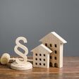 Wooden houses and paragraph figurine with judge hammer. Litigation in housing and real estate disputes. Norms and rules for construction, maintenance. Encouraging green and energy-saving technologies