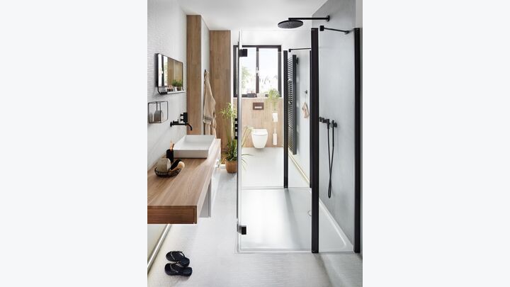 Langes Schlauchbad mit Toilette, Waschbecken und Dusche.