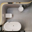 Badezimmer von oben fotografiert: Mit freistehender, ovaler Badewanne, rundem Einzelwaschbecken und WC.