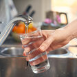 faucet water splashing freshwater domestic life drinking glass filling one woman only pouring women drink drinking indoors kitchen adult adults only body care bubble clean cold drink cup day domestic kitchen domestic room drinking water environment flowing water focus - concept food and drink freshness full hand healthy lifestyle holding home interior human body part human hand kitchen sink leaking lifestyles liquid metal one person part of people photography purity sink thirsty wet