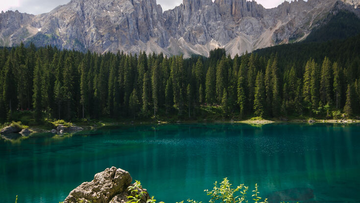 carezza lago karersee acqua smeraldo paesaggio dolomiti alpi alpino natura ambiente unesco patrimonio montagne monti trentino alto adige latemar nuvole estate vacanze viaggi turismo trekking alpinismo meraviglioso bosco alberi piante foresta selvaggia sfondo vegetazione estiva relax pace tranquillità idilliaco colore rocce cima vetta turistico bellezza