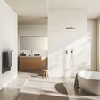 Beige bathroom interior with bathtub on light concrete floor. Sink with mirror, shower and towel rail ladder with accessories, panoramic window on tropics. 3D rendering