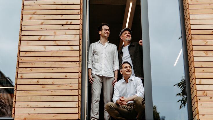 Gerald Stangl, Hüseyin Özcelik kniend und Florian Hackl-Kohlweiss (v.l.n.r.) im Roots Haus in der Linzer Straße.