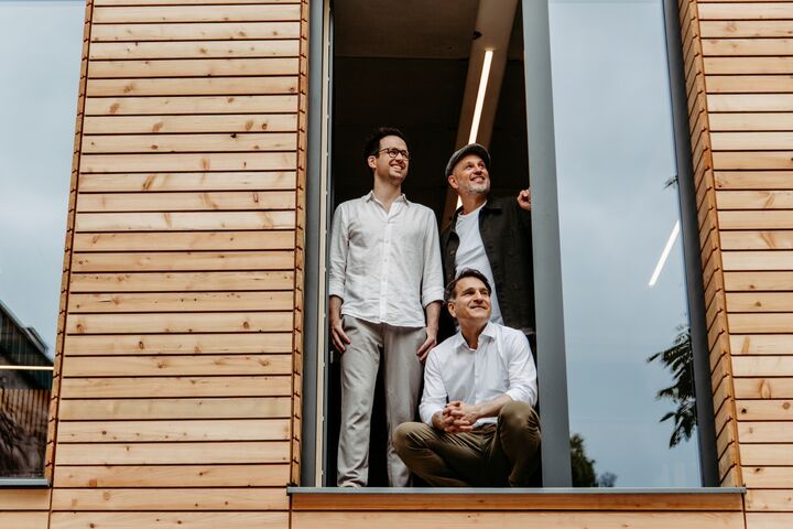 Gerald Stangl, Hüseyin Özcelik kniend und Florian Hackl-Kohlweiss (v.l.n.r.) im Roots Haus in der Linzer Straße.