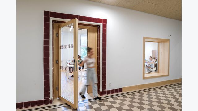 Die markanten Fliesenrahmen um die Türen zierten schon die Gänge des früheren Krankenhauses – nun bilden sie den Eingang zu den Klassenräumen. Da die Fliesen keine zusätzliche Brandlast bedeuten, sind sie aus brandschutztechnischer Sicht unbedenklich.
