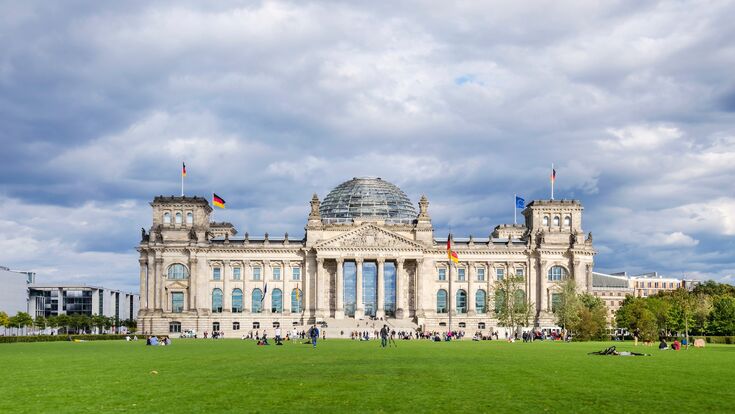 Berlin, Germany - September 9, 2015: People enjoying a warm autumn day on the lawn in front of the Reichstag, German Parliament.