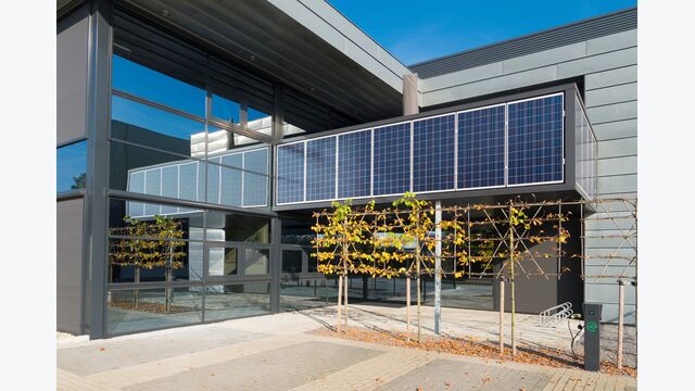 modern office building exterior with solar panels above the entrance