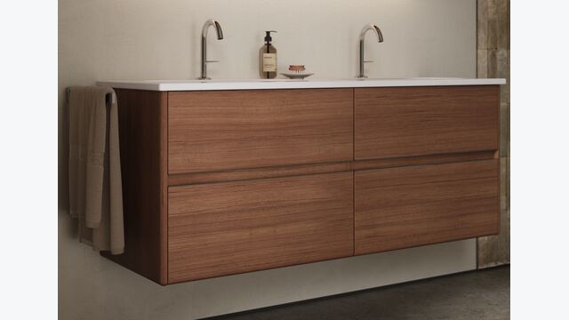Der Unterschrank in Tectona Dekor Zimt erinnert mit seinen abgerundeten Kanten und den grifflosen, flächenbündig integrierten Auszugsfronten an ein Sideboard im Mid-Century-Style.